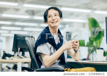 一個在辦公室操作智能手機的男人 125696013