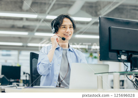 Man making a phone call in office call center 125696028