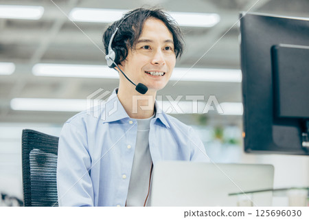 Man making a phone call in office call center 125696030