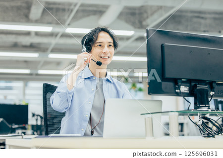 Man making a phone call in office call center 125696031