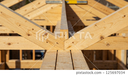 Wooden beams supporting a roof structure in construction   125697034