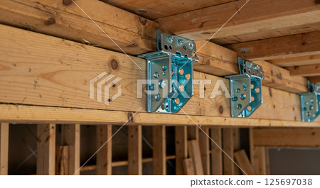 Metal Brackets Supporting Wooden Beams in Construction Setting   125697038