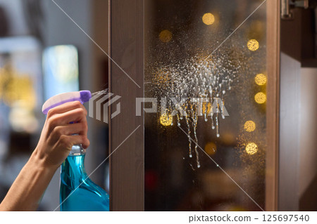 Cleaning a glass surface effectively with a spray bottle to achieve a clear, shiny finish 125697540