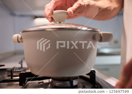 Preparing meals on the stove using a pot can be a delightful culinary experience Preparing meals on the stove using a pot can be a delightful culinary experience 125697599