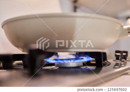 Bright Blue Flame Emanating from a Gas Burner in a Kitchen Setting Suitable for Cooking 125697602