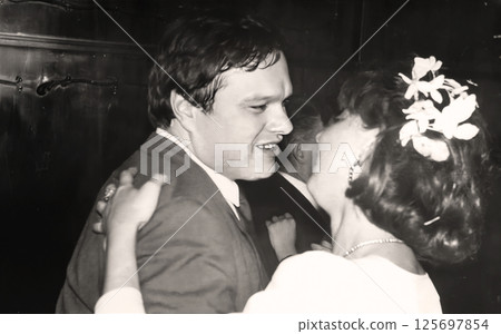 Vintage portrait of the bride and groom. The couple is dancing and talking. Retro photo from 1993. 125697854