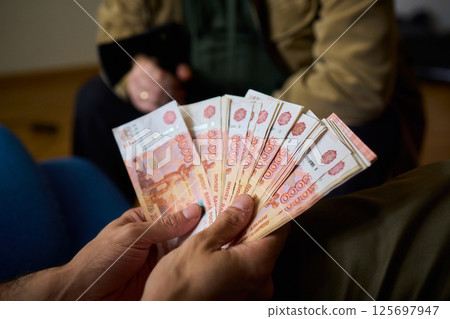 A Cash Transaction That Carries Unsettling and Uneasy Undertones of Tension and Anxiety 125697947