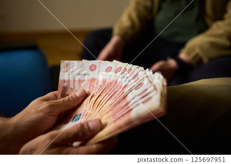 A Cash Transaction That Carries Unsettling and Uneasy Undertones of Tension and Anxiety 125697951