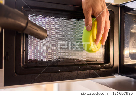 Learn to sanitize a sponge in the microwave for optimal kitchen cleanliness and hygiene 125697989