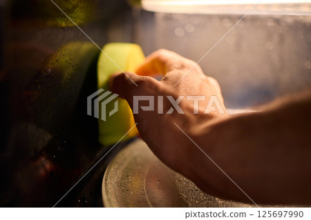Learn to sanitize a sponge in the microwave for optimal kitchen cleanliness and hygiene 125697990