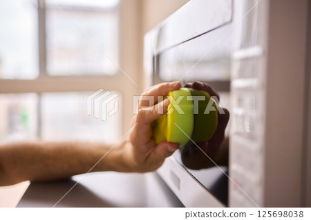 Learn to sanitize a sponge in the microwave for optimal kitchen cleanliness and hygiene 125698038