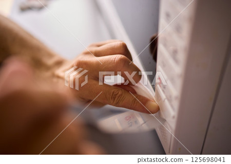 A person is meticulously hand cleaning a surface using a cloth in a bright and inviting environment 125698041