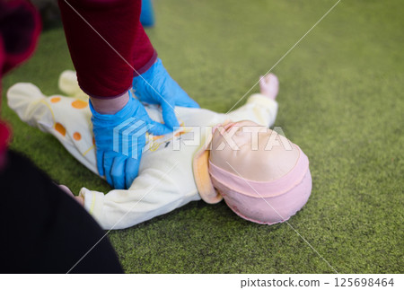 CPR training on an infant training manikin 125698464