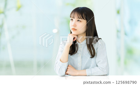 A woman thinking with her elbows on the table 125698790