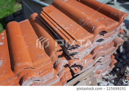 Stack of terracotta roof tiles during home renovation project 125699291
