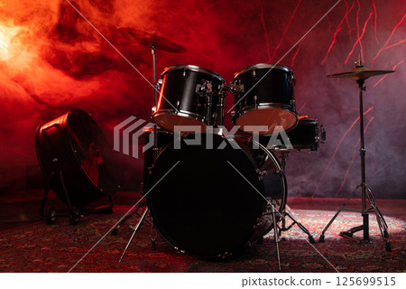 Drums and drum set. Beautiful blue and red background, with rays of light. Beautiful special effects of smoke and lighting. Musical instrument. The concept of music. Close-up photo. 125699515