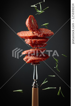 Sliced chorizo on a fork. 125699834