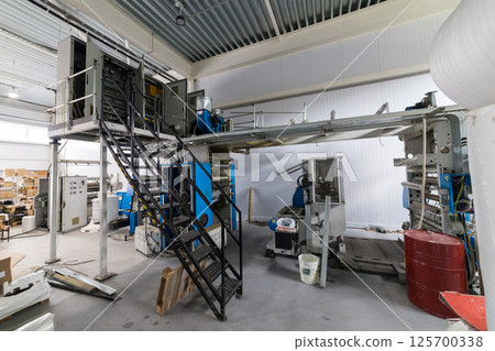Industrial printing press dominating a factory floor Industrial printing press dominating a factory floor 125700338
