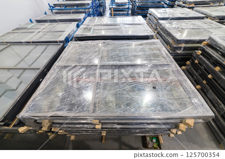 Plastic-wrapped window frames stacked in warehouse, ready for delivery Plastic-wrapped window frames stacked in warehouse, ready for delivery 125700354