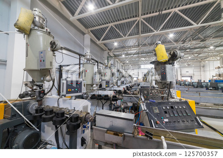 Extrusion machines processing plastic granules in factory Extrusion machines processing plastic granules in factory 125700357