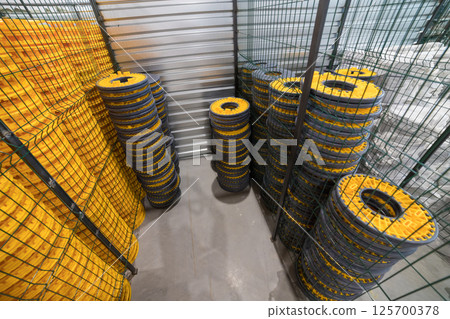 Warehouse storing stacks of yellow and grey plastic drainage cells Warehouse storing stacks of yellow and grey plastic drainage cells 125700378