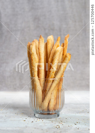 Grissini with herbs on a gray concrete background 125700446