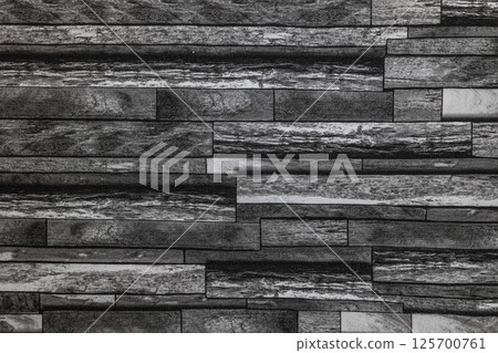 Dark stacked stone wall covering texture for modern and rustic interior design backgrounds 125700761