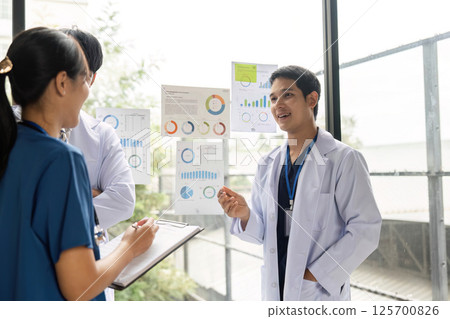 Doctors collaborating on healthcare strategies with data visuals 125700826