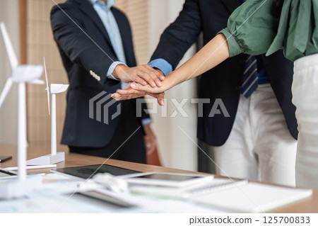 ESG and Sustainability: Close-up of hands symbolizing teamwork and partnership 125700833