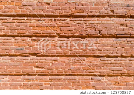 Textured Red Brick Wall with Horizontal Indentations Textured Red Brick Wall with Horizontal Indentations 125700857