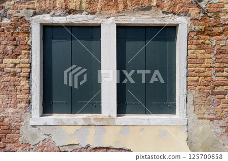 Aged Brick Wall with Closed Wooden Shutters Aged Brick Wall with Closed Wooden Shutters 125700858