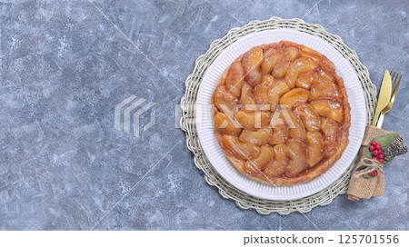 Delicious tarte tatin with caramelized apples, festive table setting, horizontal top view copy space 125701556