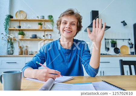 Webcam portrait male student teenager, sitting at home at the table Webcam portrait male student teenager, sitting at home at the table 125702610