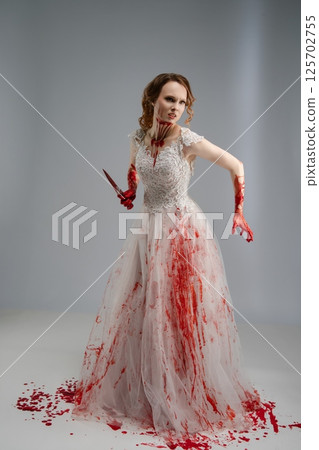 Bridal beauty transformed into a fierce warrior with a katana and blood 125702755