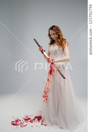 Bridal beauty with a katana in a dramatic portrayal of vengeance and elegance 125702756
