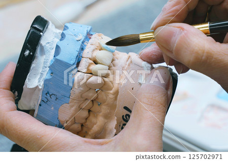 Expert craftsmanship in creating ceramic dentures in modern dentistry laboratory 125702971