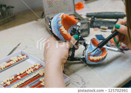 Expert dental technician crafts detailed dentures with precision and skill 125702991