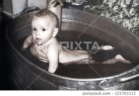 Vintage portrait of a baby bathing in a basin. Retro photo from 1966. USSR. Vintage portrait of a baby bathing in a basin. Retro photo from 1966. USSR. 125703115