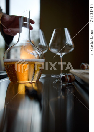 Decanter for sparkling wine on the table, Champagne tasting, Wine glasses, reflections, rose wine Decanter for sparkling wine on the table, Champagne tasting, Wine glasses, reflections, rose wine 125703716