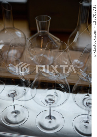 Clean wine glasses are on the table of a special wine cabinet, stylish table setting, ice, bottle of sparkling wine, light from window, decanter and degasser Clean wine glasses are on the table of a special wine cabinet, stylish table setting, ice, bottle of sparkling wine, light from window, decanter and degasser 125703733