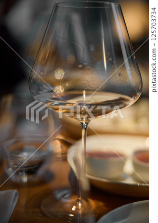 A glass of sparkling wine in close-up, Champagne tasting, Wine glasses are on the table, stylish table setting, sparkling wine bubbles, oysters and sea urchins, special sauce A glass of sparkling wine in close-up, Champagne tasting, Wine glasses are on the table, stylish table setting, sparkling wine bubbles, oysters and sea urchins, special sauce 125703734