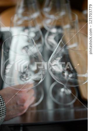 Clean wine glasses are on the table of a special wine cabinet, stylish table setting, ice, bottle of sparkling wine, light from window, decoder and degasser Clean wine glasses are on the table of a special wine cabinet, stylish table setting, ice, bottle of sparkling wine, light from window, decoder and degasser 125703779