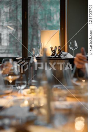 Several bottles of champagne are cooled in a niche with ice in the restaurant, local lighting, wine cabinet, decanters for sparkling wine 125703792