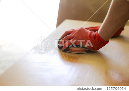 sanding a wooden surface with a sander sanding a wooden surface with a sander 125704054