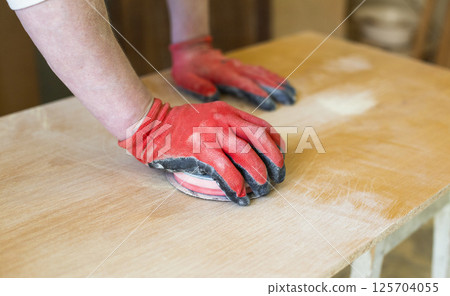 Manual Wood Sanding Process in Carpentry Workshop Close-Up Manual Wood Sanding Process in Carpentry Workshop Close-Up 125704055