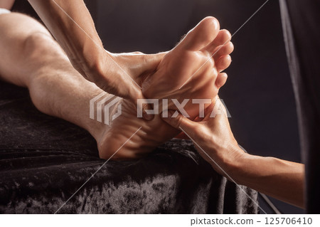 Close-up of professional foot massage session, therapist applying pressure for relaxation and pain relief. Close-up of professional foot massage session, therapist applying pressure for relaxation and pain relief. 125706410