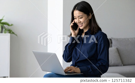 A Japanese woman operating a laptop computer 125711382