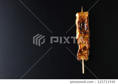 在黑色背景下拍攝的烤鰻魚串 在黑色背景下拍攝的烤鰻魚串 125711430