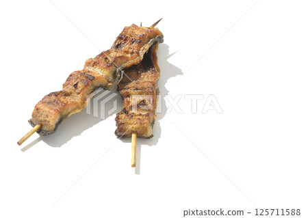 Grilled eel skewers photographed on a white background 125711588