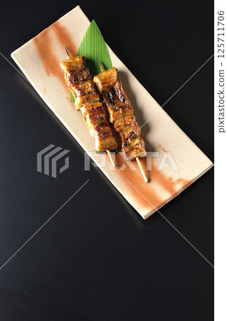 在黑色背景下拍攝的烤鰻魚串 125711706